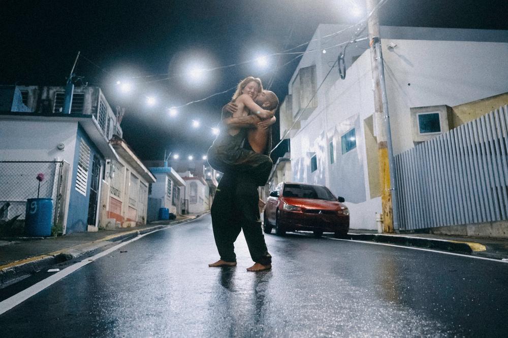 Ohrangutang lifting Alanna Jade on a rain-wet street in Puerto Rico