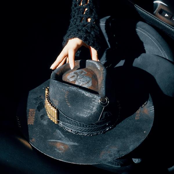 A worn cowboy hat in hand